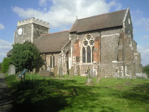 Flint and stone walls and west tower of St Mary the Virgin Church, Stone, above its churchyard