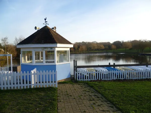 Boat hire kiosk and white picket fence beside the lake in Swanley Park