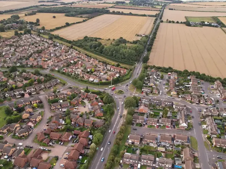 Aerial view over an English housing estate with rows of tiled roofs, the kind of homes now past their 10-year new-build warranty