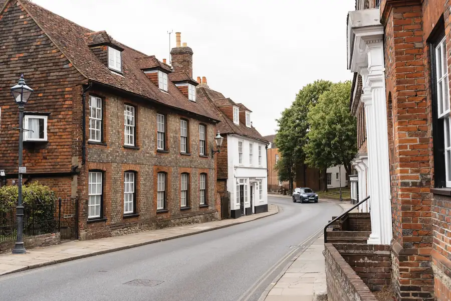 Georgian brick houses with clay tile roofs and dormers along a quiet street, similar to older roofs in Dartford's town centre conservation area