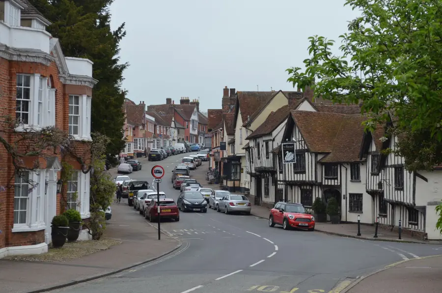 Historic English high street with timber-framed and brick buildings under clay tile roofs, the sort of setting where planning rules on re-roofing tighten