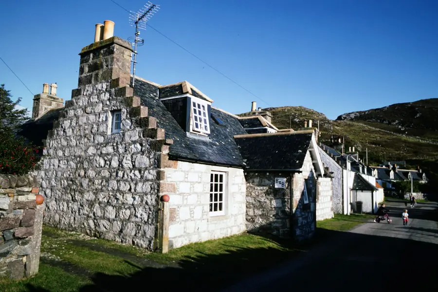 Stone cottage with a natural slate roof and chimney, the kind of covering that can't simply be swapped for heavier concrete tiles