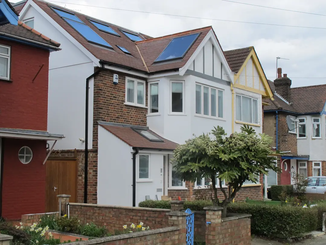 Extended semi-detached house with several roof windows set into the tiled roof slopes of a loft conversion