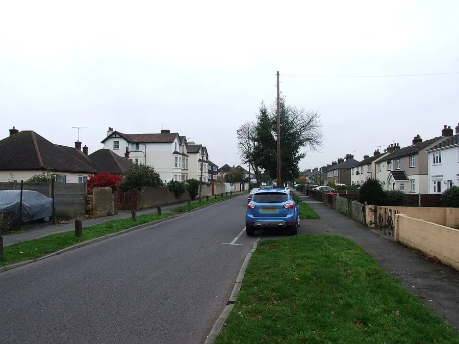 Houses with pitched roofs along a grass verge on Carlton Avenue, Stone