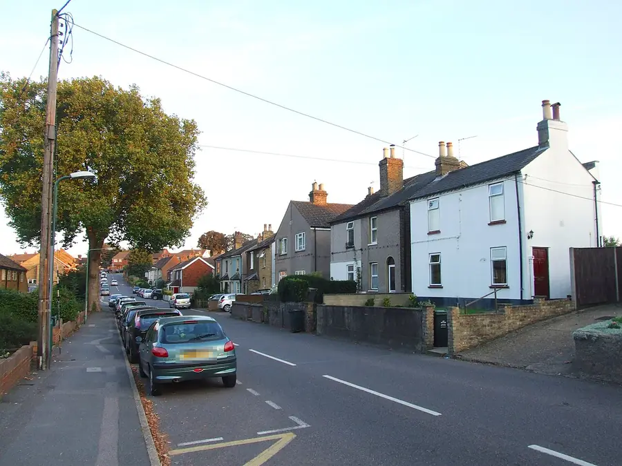 Row of older cottages with chimneys and pitched roofs on Common Lane, Wilmington